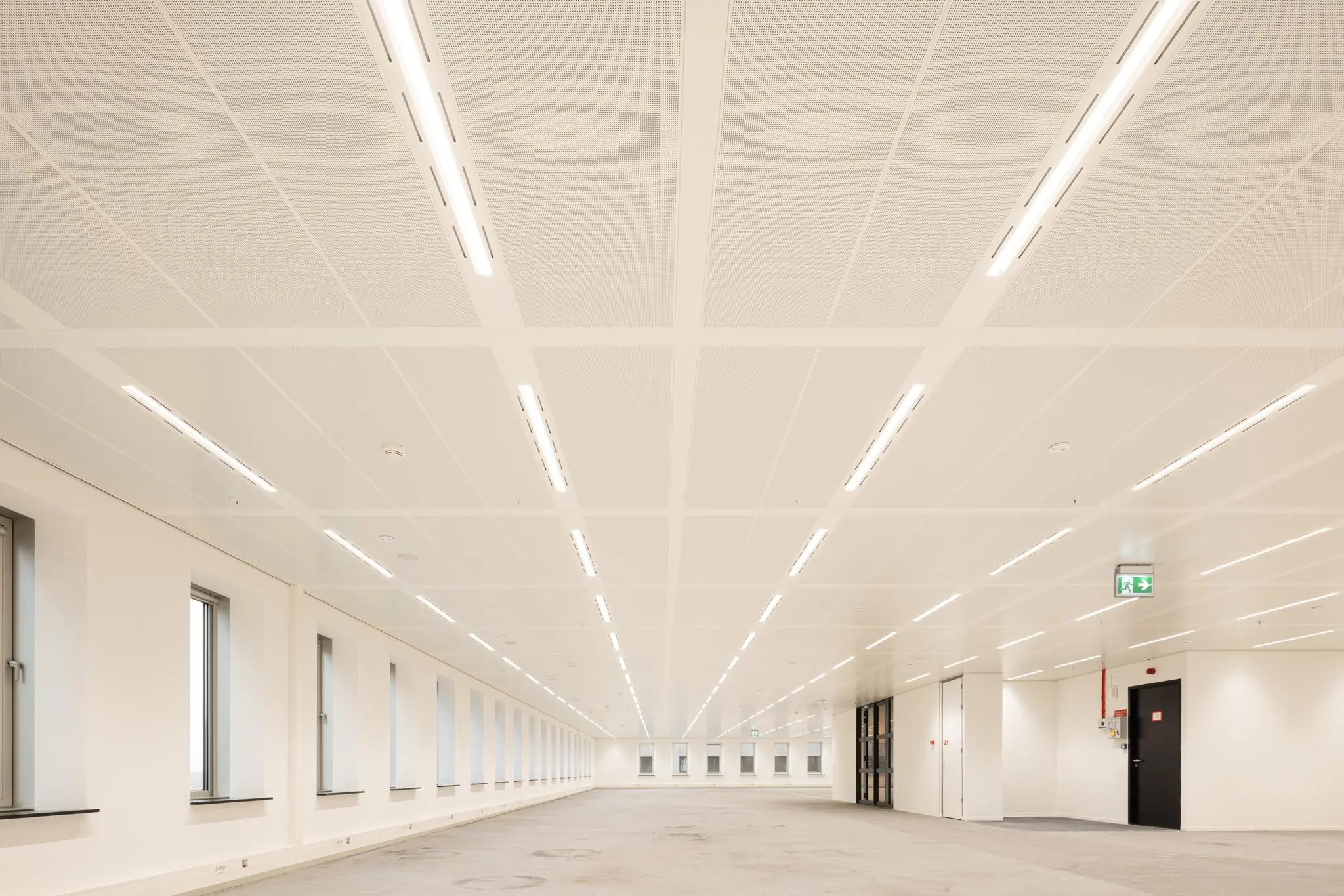 Licht en ruim leeg kantoorpand aan de Prinses Beatrixlaan met rijen ramen en systeemplafondverlichting.